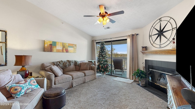 carpeted living room with a textured ceiling, ceiling fan, a fireplace, and vaulted ceiling