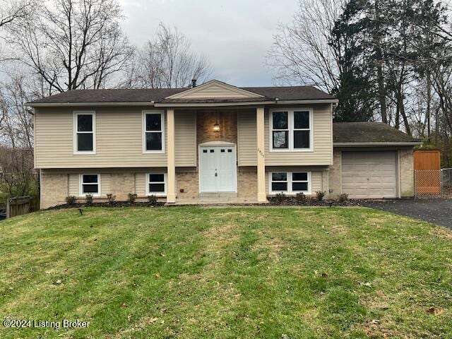 split foyer home with a garage and a front lawn