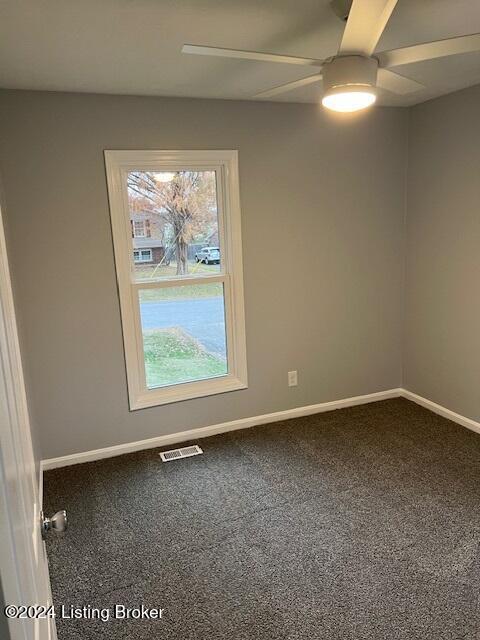 unfurnished room with ceiling fan and carpet