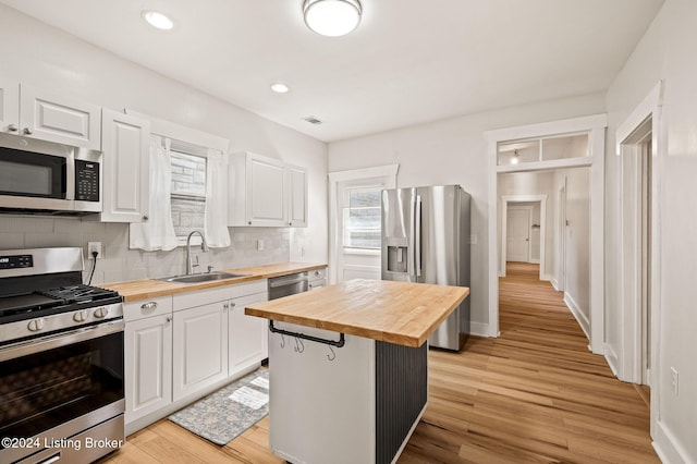 kitchen with white cabinets, wood counters, sink, and appliances with stainless steel finishes