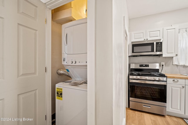 laundry area featuring light hardwood / wood-style flooring and stacked washer / drying machine