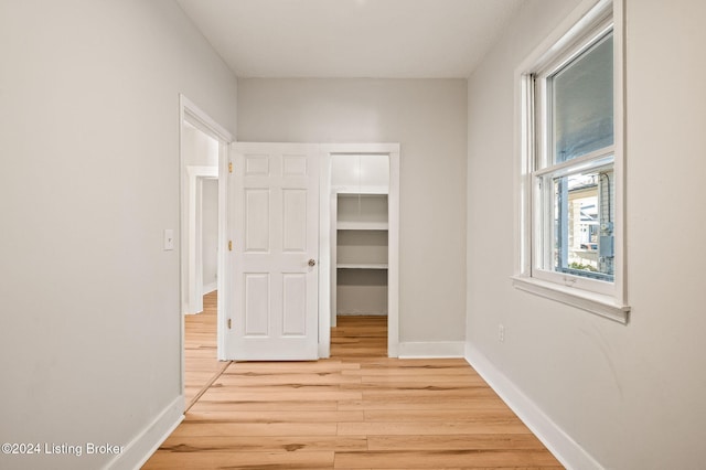 interior space with a closet, a walk in closet, and light hardwood / wood-style flooring