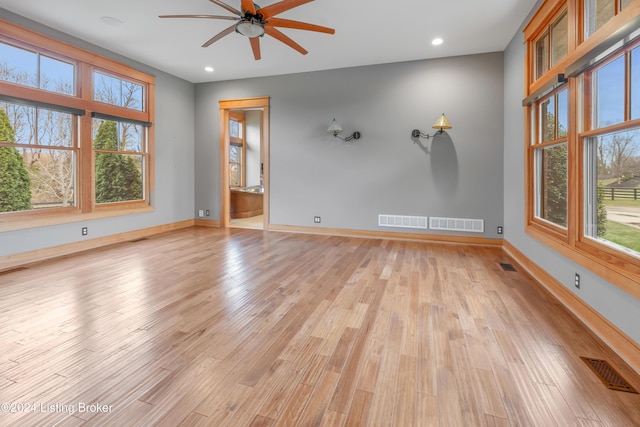 unfurnished room with a wealth of natural light, ceiling fan, and light hardwood / wood-style floors