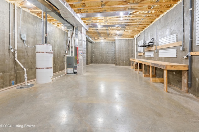 basement featuring a workshop area and heating unit