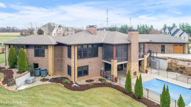 back of house featuring a yard, a fenced in pool, and cooling unit