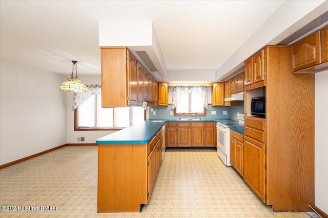 kitchen featuring a wealth of natural light, electric range, sink, and decorative light fixtures