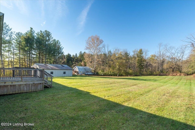 view of yard featuring an outdoor structure and a deck