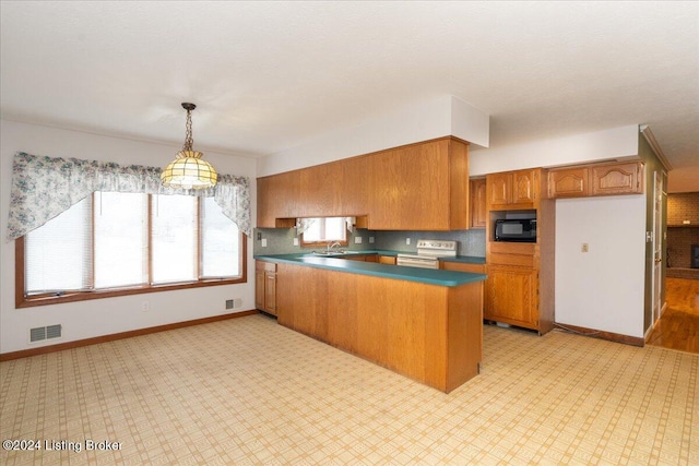 kitchen with sink, decorative light fixtures, electric range oven, kitchen peninsula, and black microwave