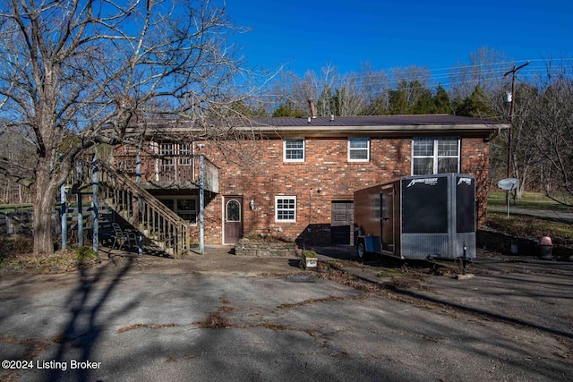 back of property with a sunroom and a wooden deck