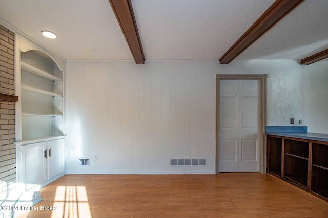 interior space with built in shelves, crown molding, light hardwood / wood-style flooring, and beamed ceiling