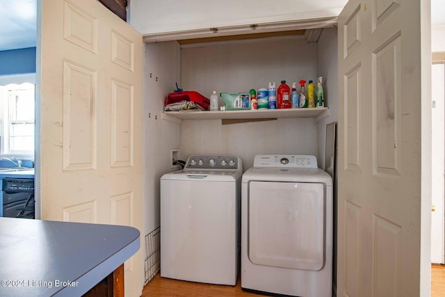 washroom featuring light wood-type flooring, separate washer and dryer, and sink