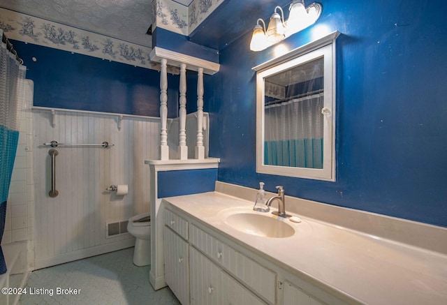 bathroom with vanity, a textured ceiling, and toilet