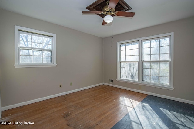 spare room with hardwood / wood-style floors, ceiling fan, and a healthy amount of sunlight