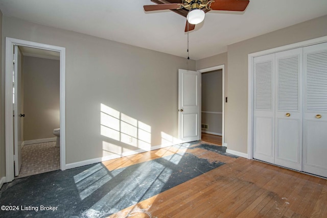 unfurnished bedroom with ceiling fan, dark hardwood / wood-style flooring, ensuite bath, and a closet