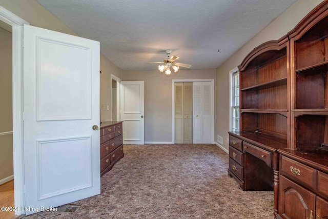 interior space featuring light carpet, a textured ceiling, and ceiling fan