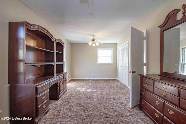 interior space with ceiling fan, light colored carpet, and a textured ceiling