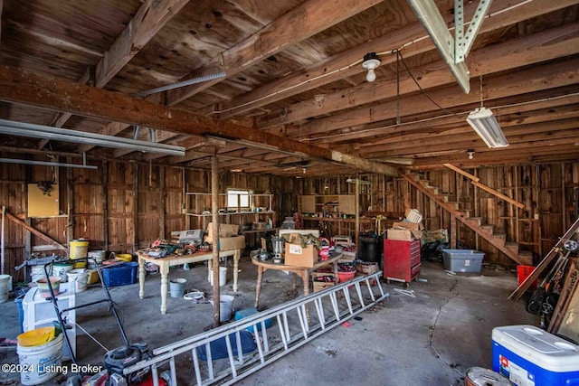 miscellaneous room featuring wooden walls and concrete floors