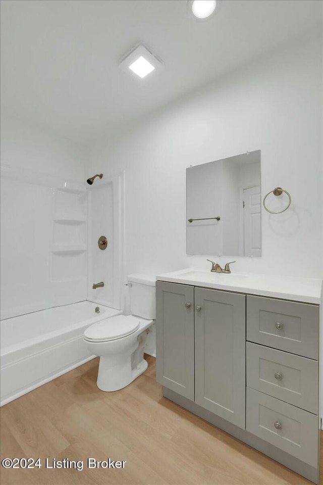 full bathroom with vanity, wood-type flooring,  shower combination, and toilet