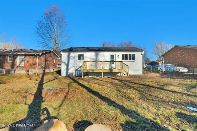 back of house featuring a wooden deck and a yard