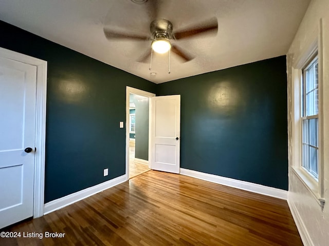 unfurnished bedroom featuring hardwood / wood-style floors and ceiling fan