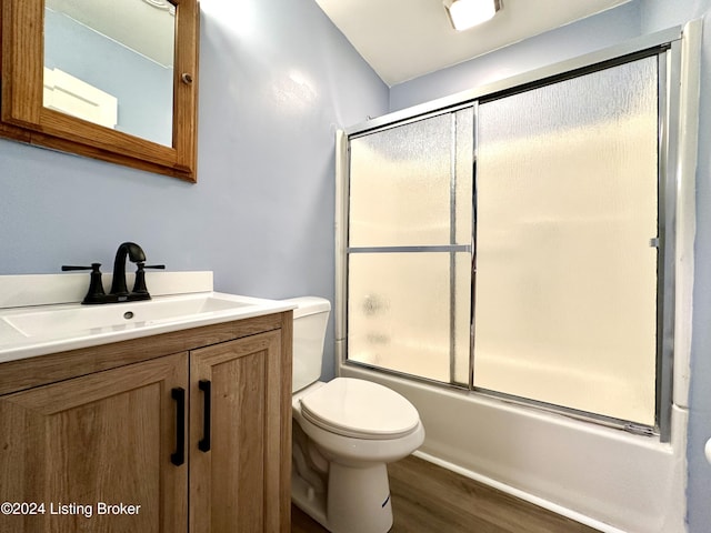 full bathroom featuring wood-type flooring, vanity, toilet, and enclosed tub / shower combo