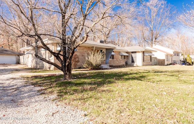 ranch-style house featuring a garage and a front lawn