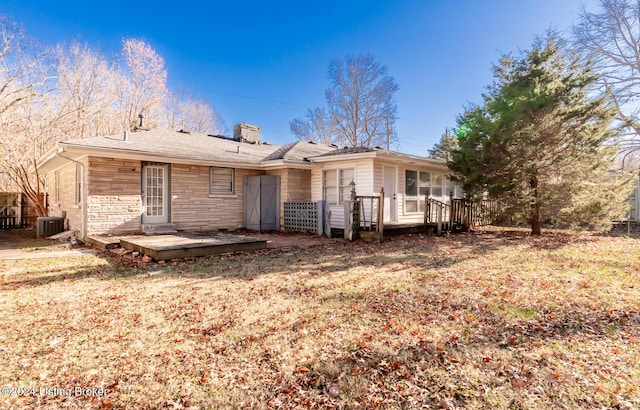 back of property featuring a lawn, cooling unit, and a deck