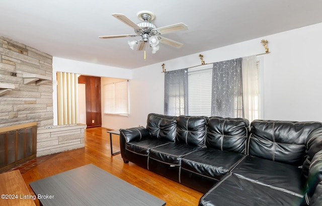 living room with hardwood / wood-style flooring, ceiling fan, and a fireplace