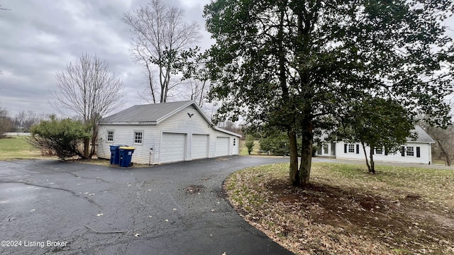 view of property exterior with a garage and an outdoor structure