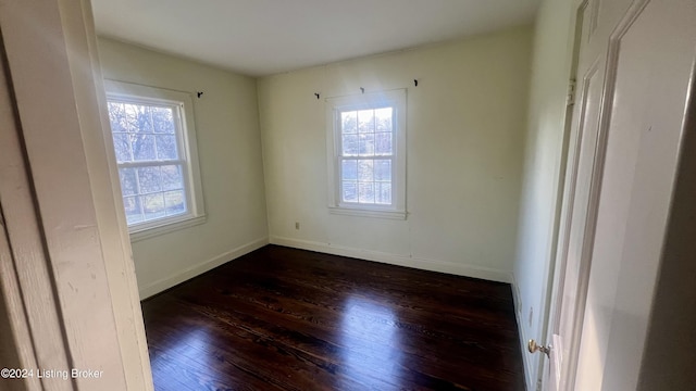 unfurnished room with dark hardwood / wood-style floors and plenty of natural light