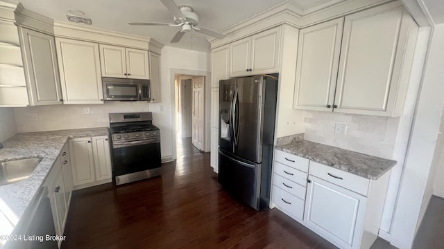 kitchen with tasteful backsplash, light stone counters, dark hardwood / wood-style flooring, and appliances with stainless steel finishes