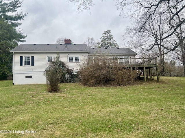 rear view of house featuring a lawn and a wooden deck