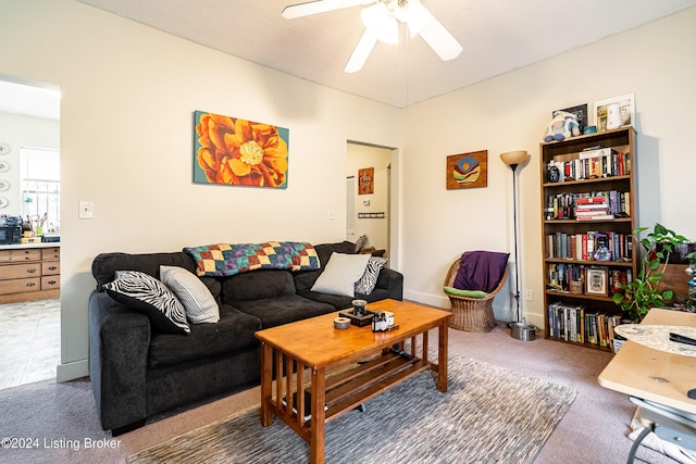 living room featuring dark colored carpet and ceiling fan