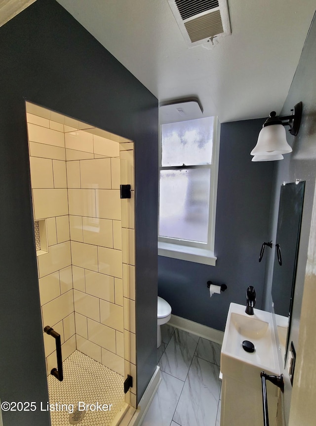 bathroom featuring toilet, vanity, and tiled shower