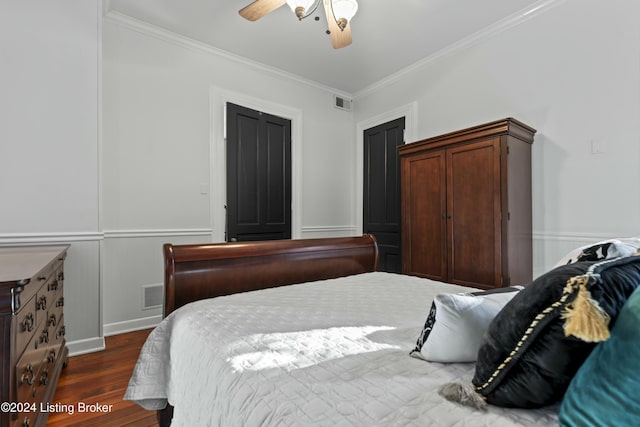 bedroom featuring dark hardwood / wood-style flooring, ceiling fan, and crown molding