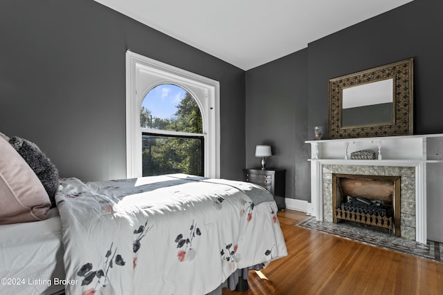 bedroom featuring a fireplace and hardwood / wood-style floors