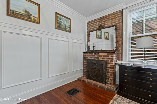 interior details featuring wood-type flooring, a brick fireplace, and crown molding