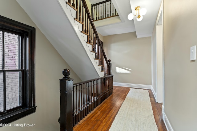 stairway featuring wood-type flooring and a chandelier