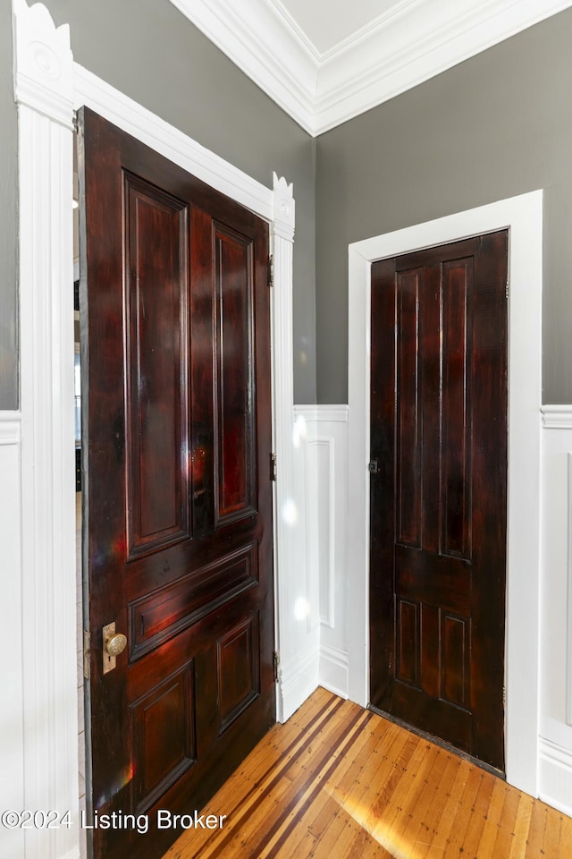 foyer with crown molding and hardwood / wood-style flooring