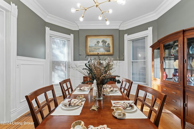 dining area featuring light hardwood / wood-style floors, crown molding, and a notable chandelier