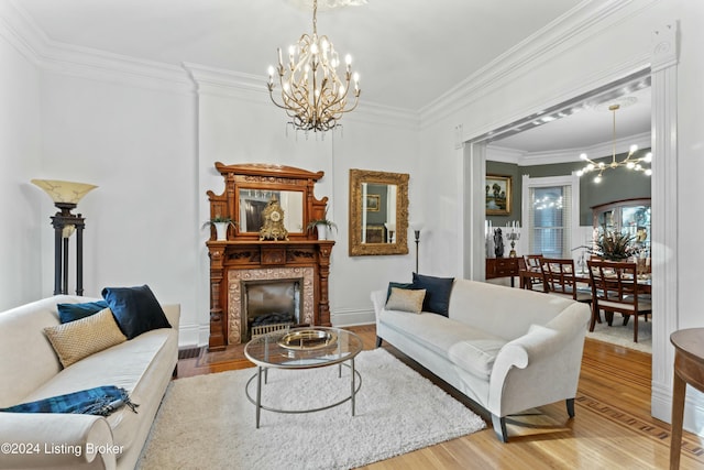 living room featuring wood-type flooring, an inviting chandelier, and ornamental molding