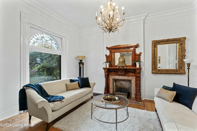 living room with hardwood / wood-style flooring, ornamental molding, and a notable chandelier