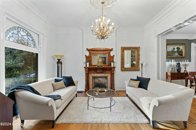 living room with hardwood / wood-style floors, a notable chandelier, and crown molding