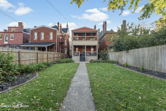 rear view of property featuring a lawn