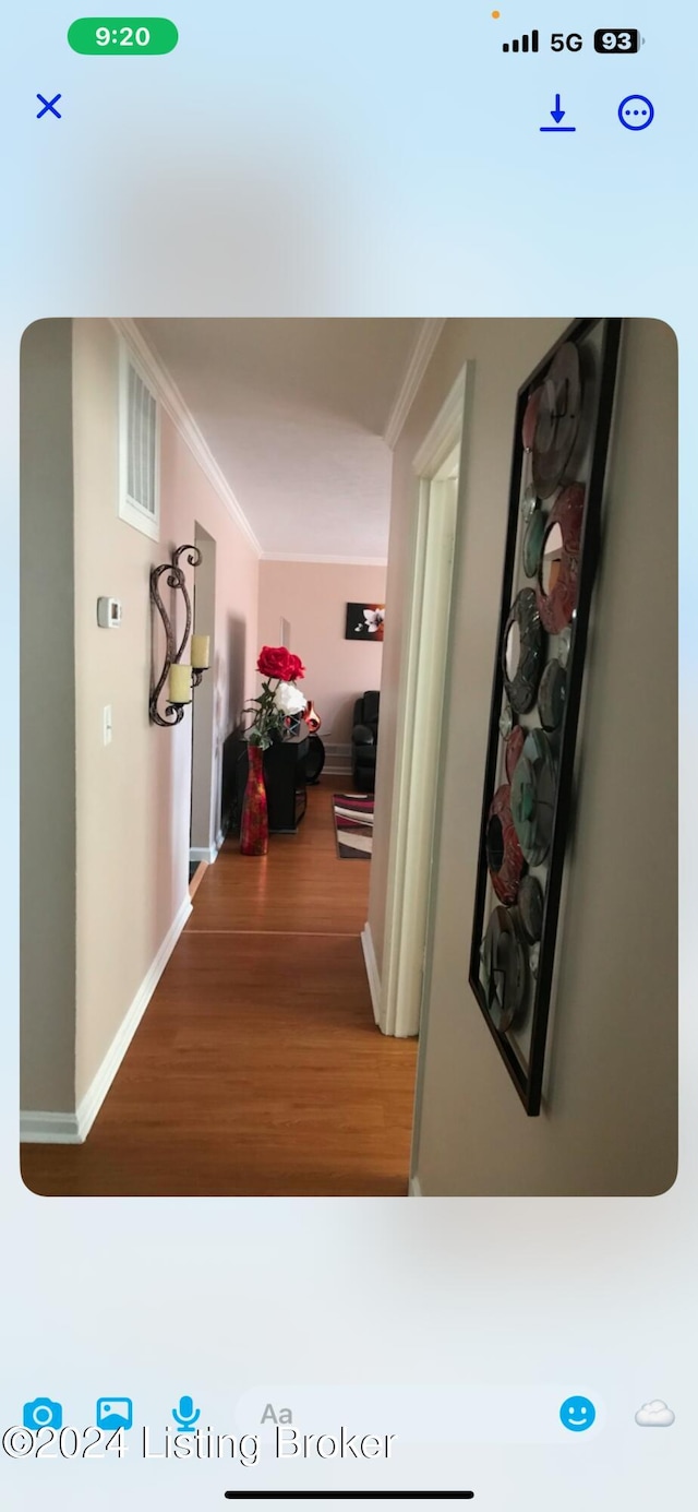 corridor featuring hardwood / wood-style floors and ornamental molding