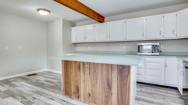 kitchen with white cabinets, beam ceiling, light wood-type flooring, and white dishwasher