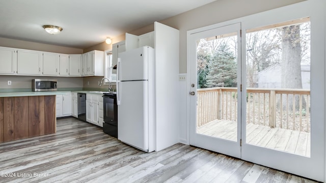 kitchen with sink, light wood-type flooring, white cabinetry, and black appliances