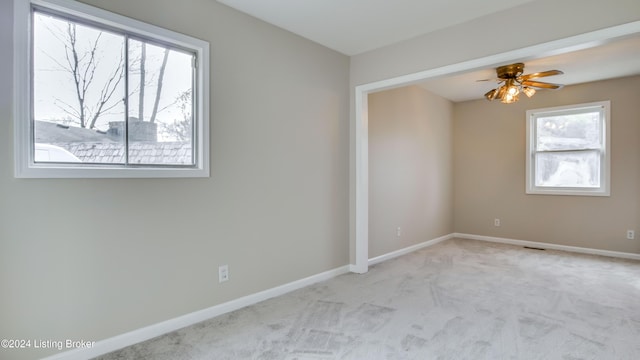 carpeted empty room featuring plenty of natural light and ceiling fan