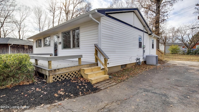 view of side of home with central AC and a deck