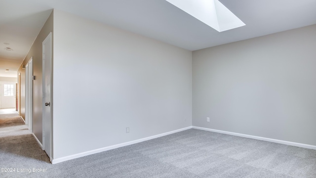 spare room featuring carpet flooring and a skylight